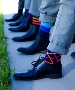 Quirky socks worn by men in a line. Socks are often a last moment gift for fathers day.