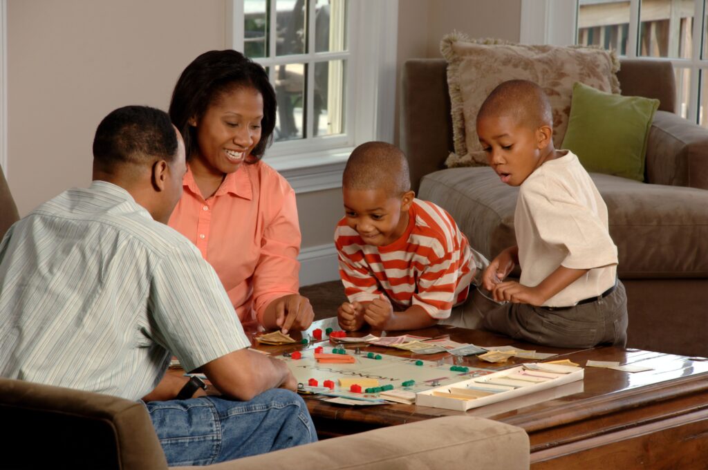 A family enjoying a board game. That is a great lockdown idea.