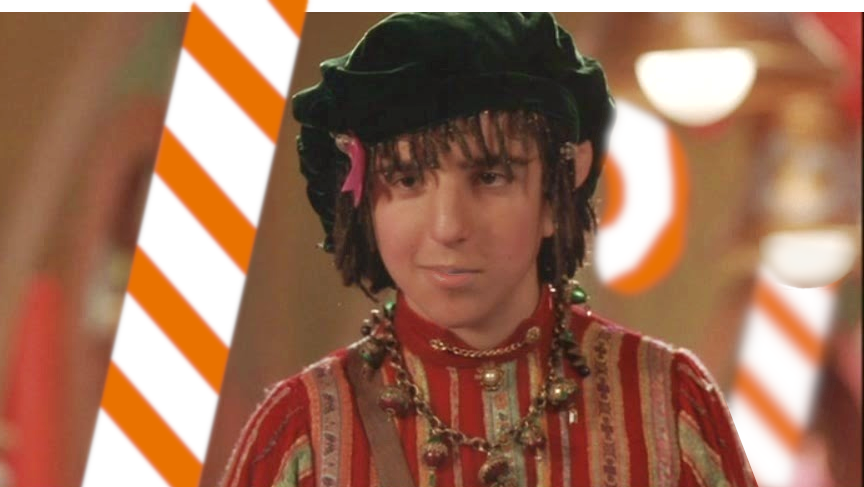 David Krumholtz as Benard the head Elf in the film Santa Clause. Sneaky Dog Escapes coloured candy cane in the background.